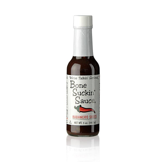 Bouteille de Bone Suckin' Sauce Habanero BBQ Sauce (Hiccuppin-Hot) de Ford's Food, 147 ml, sur une table en bois avec l'étiquette et un bol de piments Habanero montrant la sauce BBQ la plus forte, développée dans un équilibre parfait de piquant et d'arôme, avec un avertissement indiquant qu'une goutte de sauce suffit et que le yaourt ou les produits laitiers sont à la rescousse, à couper le souffle !